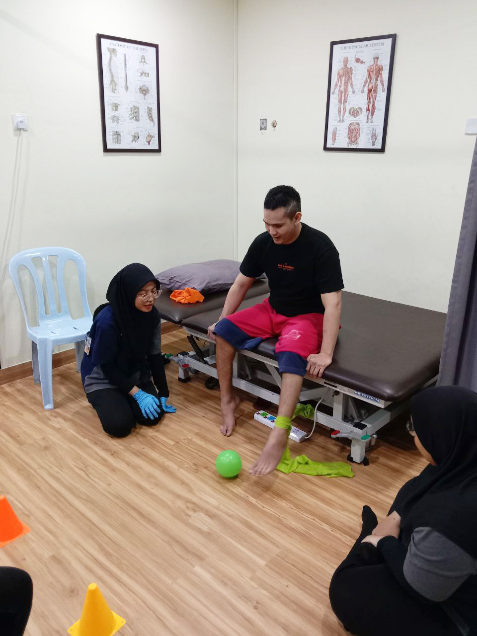 Terapis membimbing pesakit dalam latihan menguatkan kaki