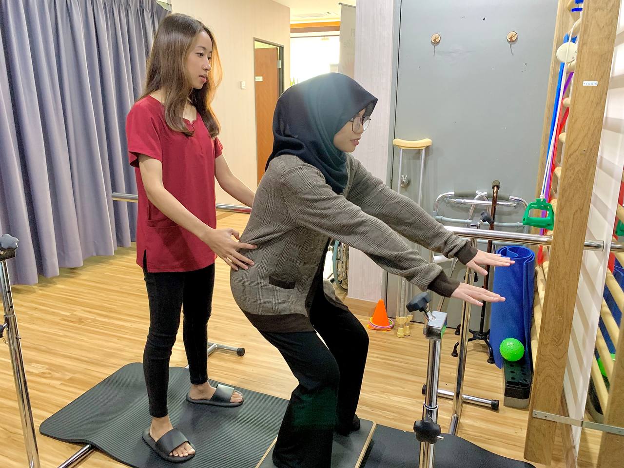 Terapis membimbing pesakit dalam latihan keseimbangan dan postur