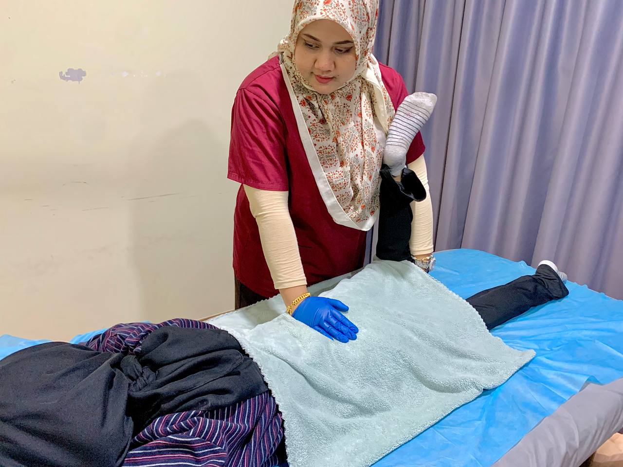 Terapis menjalankan terapi manual dan regangan kaki pesakit
